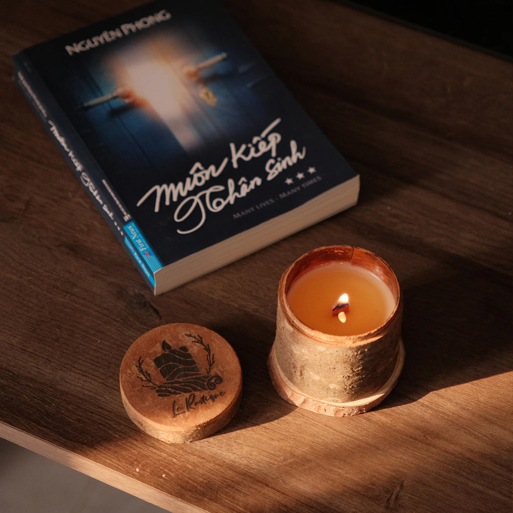 a natural soy wax candle in wood jar and book for relaxing