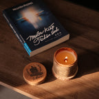 a natural soy wax candle in wood jar and book for relaxing