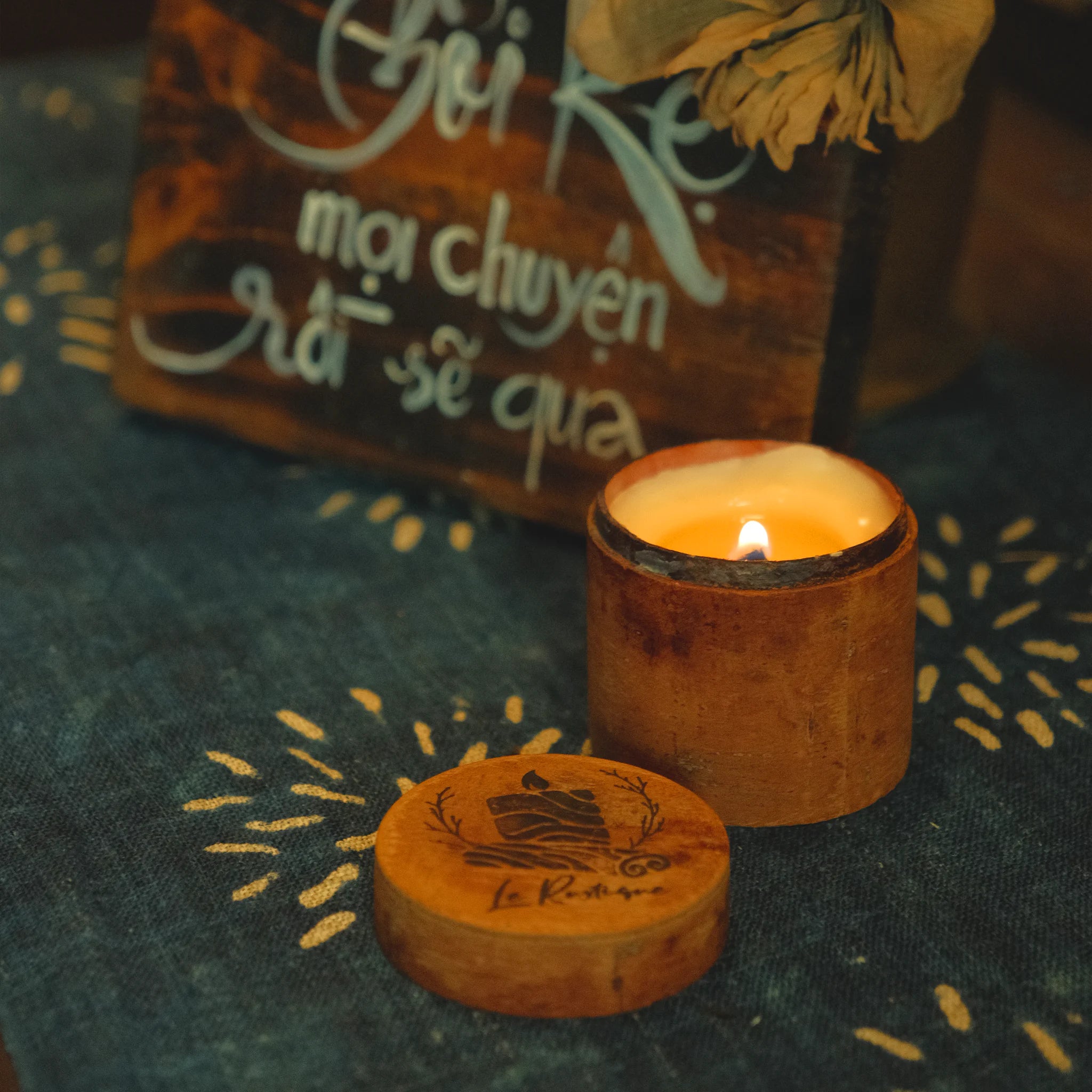Wooden candle holder with a lit candle on a textured fabric background for healing and relaxing 